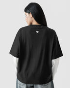 Person wearing a black t-shirt with a logo on the back against a light gray background
