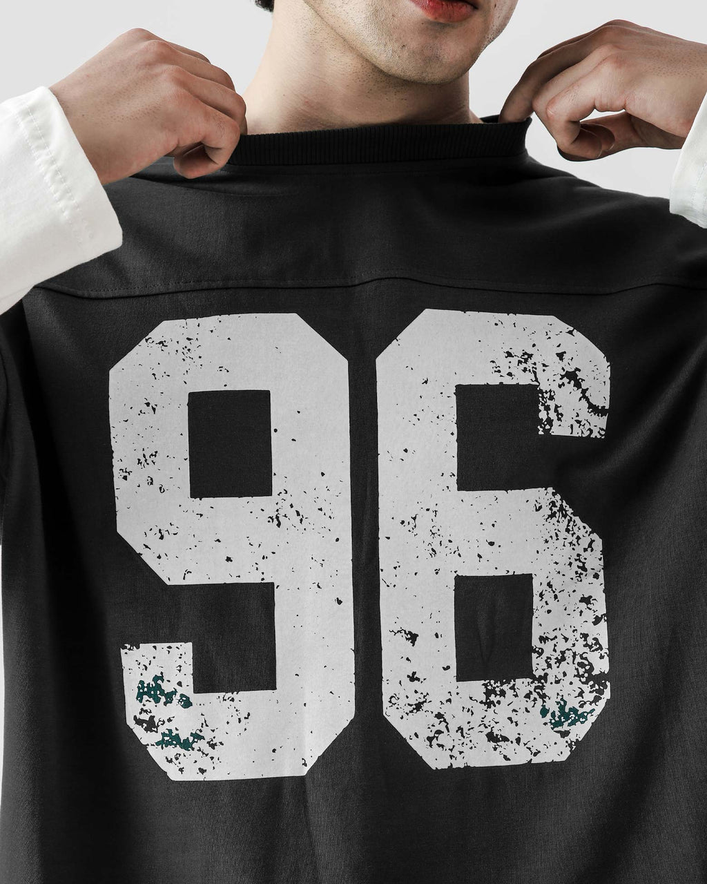 Person wearing a black jersey with the number 96 on a plain background