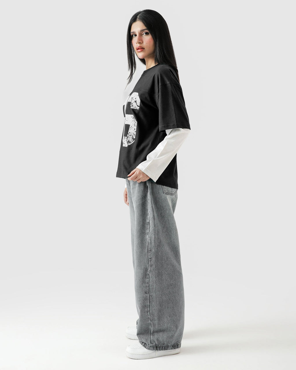 Person wearing a black and white outfit with a graphic design on a white background