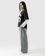 Person wearing a black and white outfit with a graphic design on a white background
